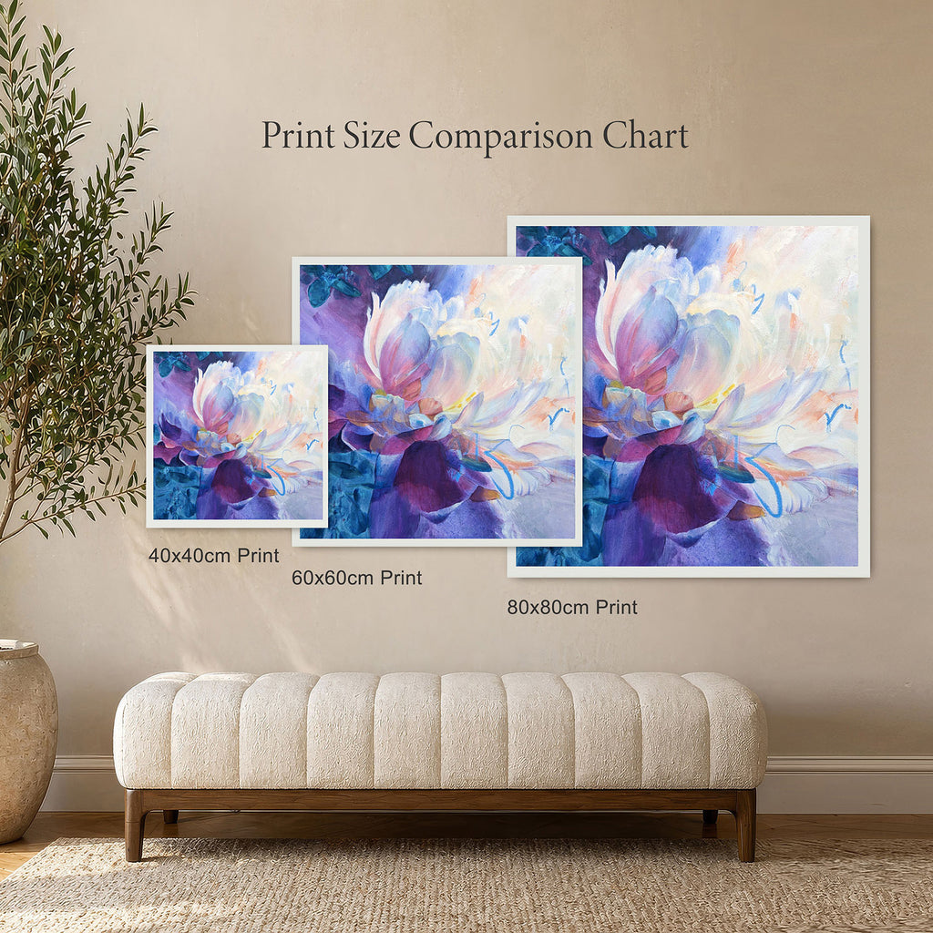 Three floral art prints of different sizes on a wall with a bench and plant.